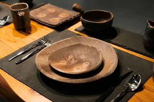 吳孟哲　餐具組2019　（大盤）29x27x3.5cm　以穴窯裸燒七天，攝氏1326度（溫錐12）；燒製時大盤放在舌尖的部分有悶炭的效果。